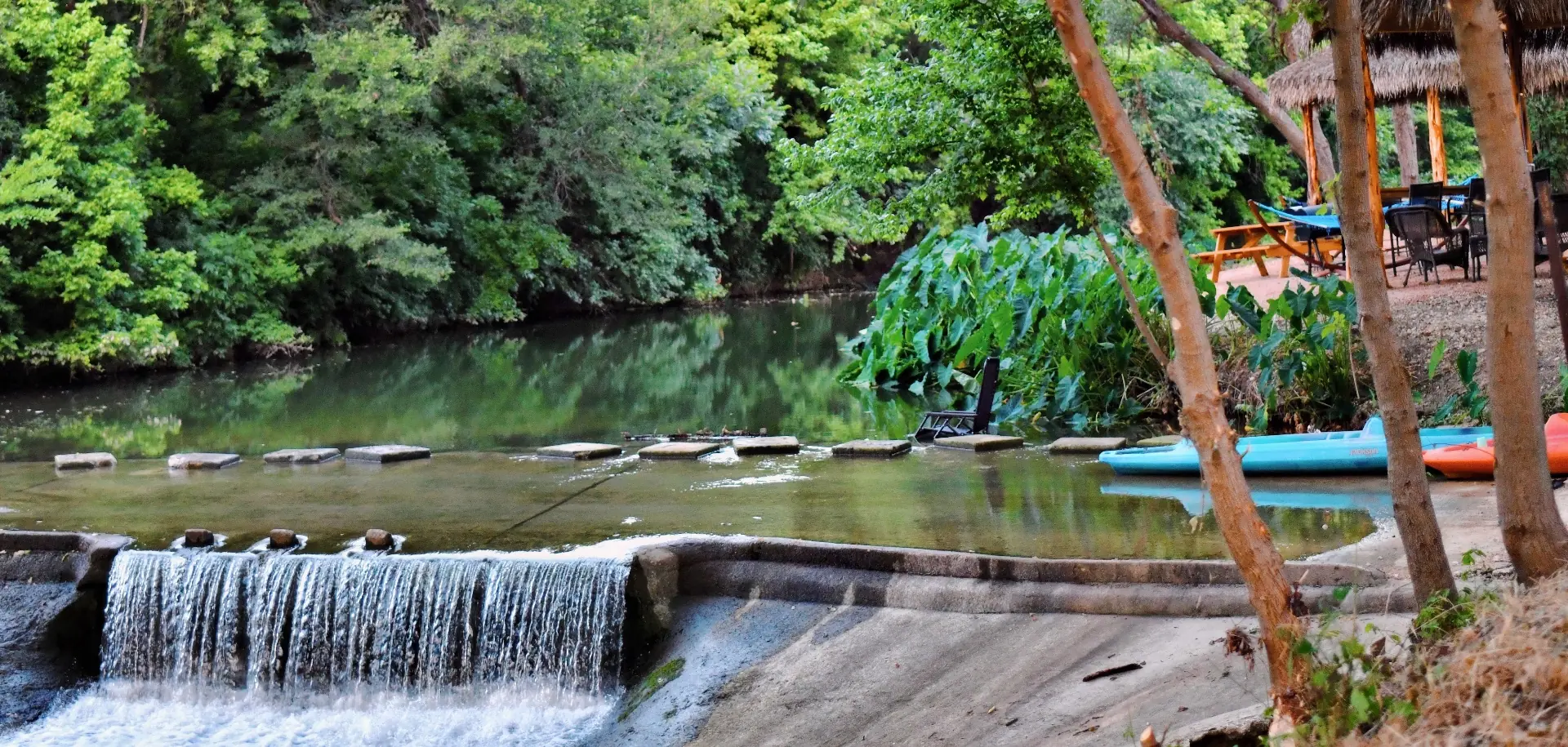 Spring-fed creek waterfall with kayaks at church retreat venue near San Antonio Texas