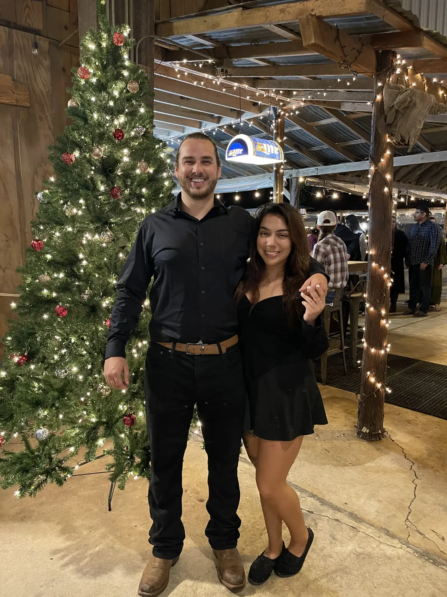 Couple by Christmas tree at company holiday celebration